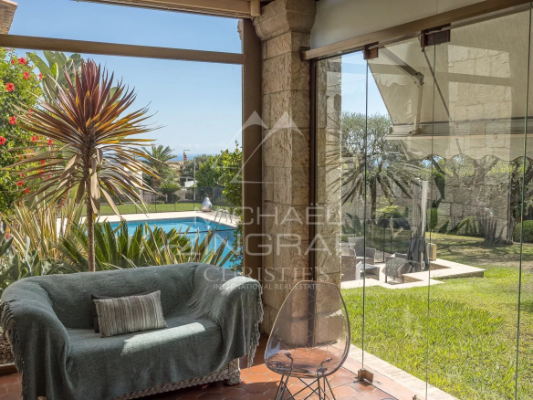 Intérieur d'une véranda avec vue sur le jardin et la piscine, Nice Fabron.
