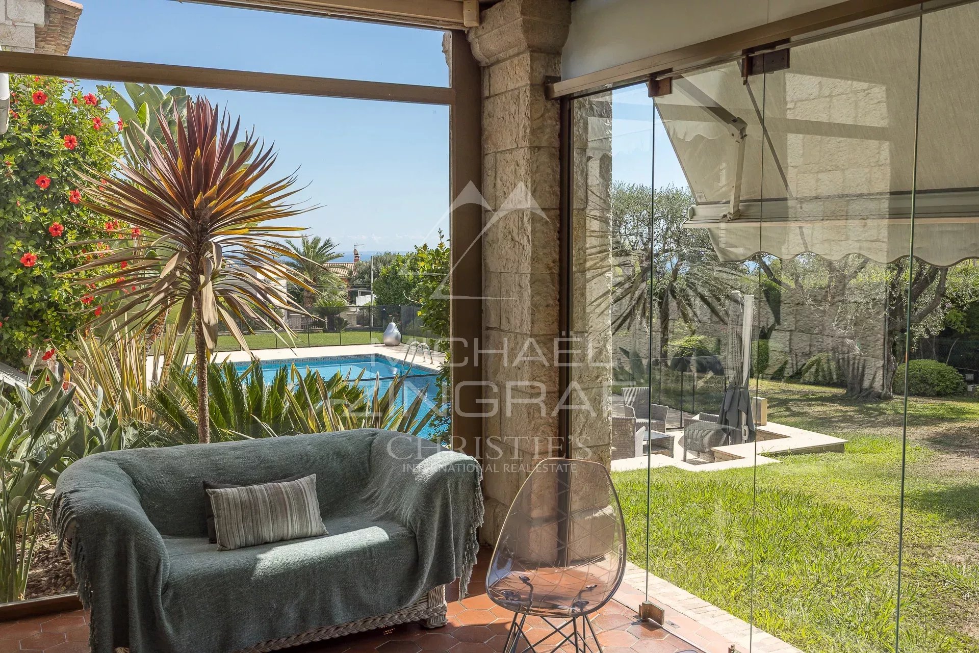 Véranda avec vue sur le jardin à Nice Intérieur d'une véranda avec vue sur le jardin et la piscine, Nice Fabron.