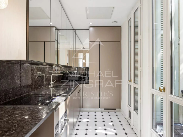 Modern kitchen with marble countertop and black and white tiles in an apartment in Nice.