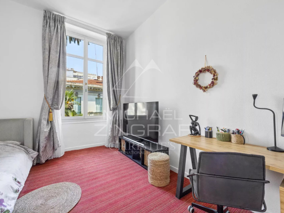 Room in a Nice apartment with a desk, television and windows overlooking the outside.