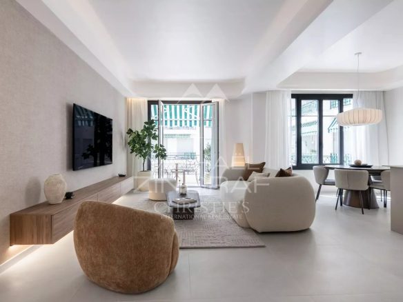 Interior of a renovated apartment with a bright living room, modern armchairs and a balcony.