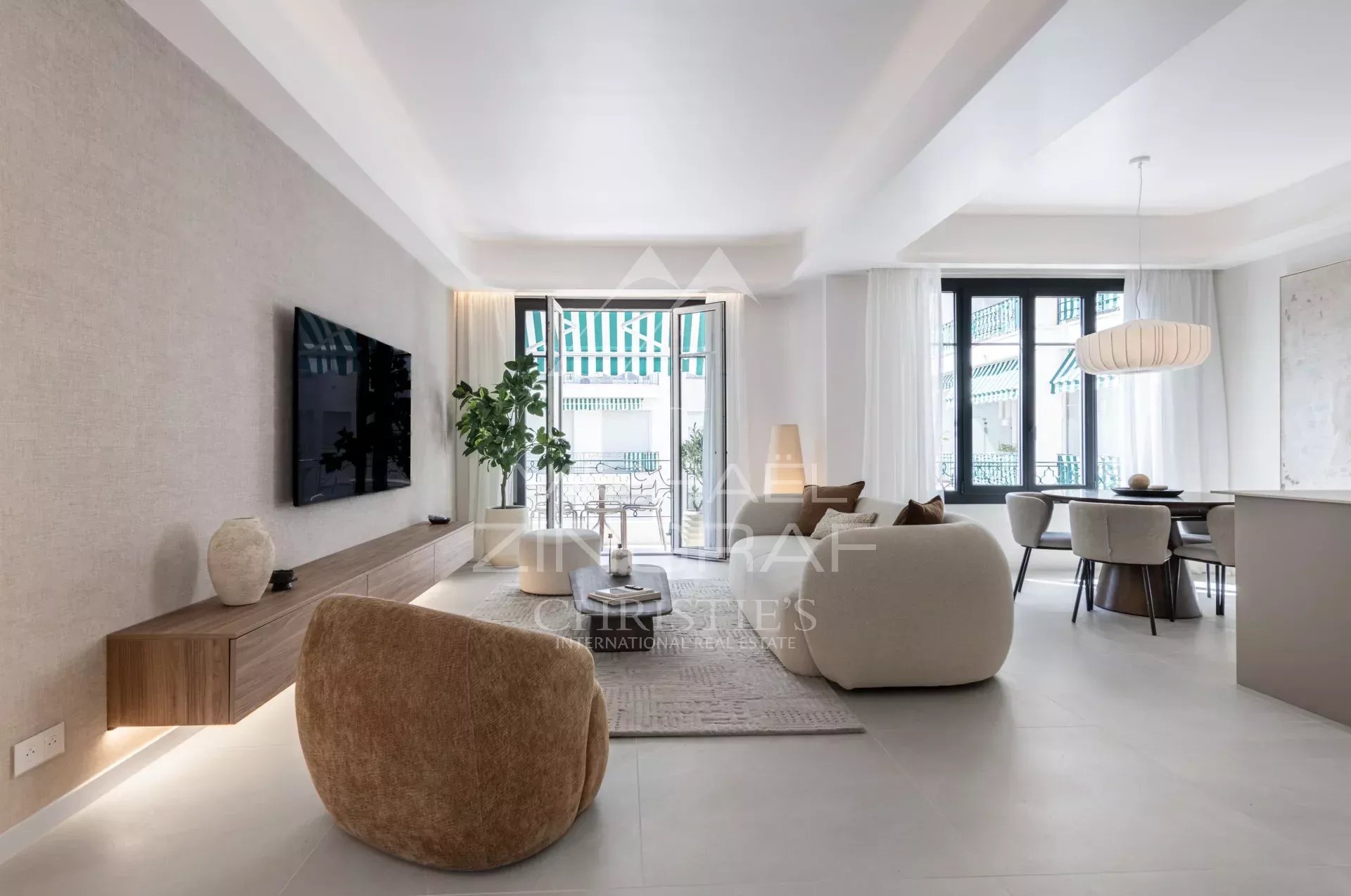 Interior of a renovated apartment with a bright living room, modern armchairs and a balcony.