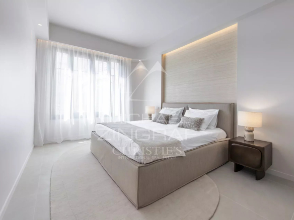 Room in a renovated apartment with a double bed and bright windows.