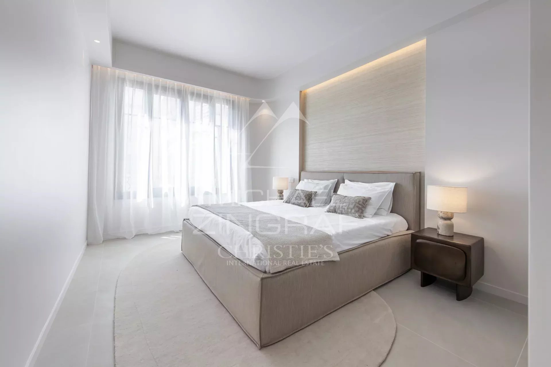 Room in a renovated apartment with a double bed and bright windows.