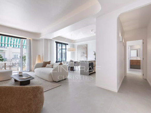 Interior of a renovated apartment with a bright living room, two bedrooms and access to a balcony.