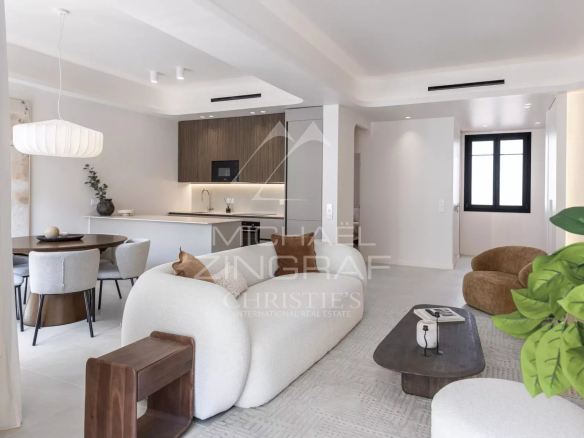 Interior of a renovated apartment with living room, open kitchen and dining area.