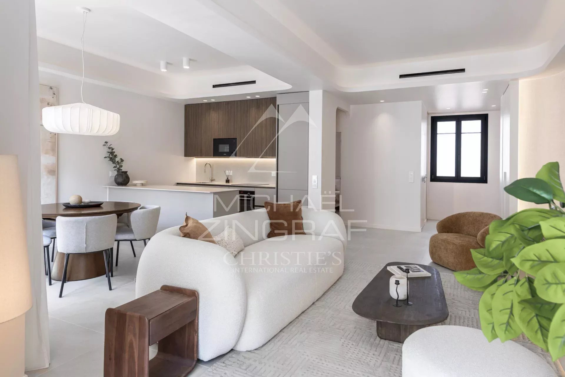 Interior of a renovated apartment with living room, open kitchen and dining area.