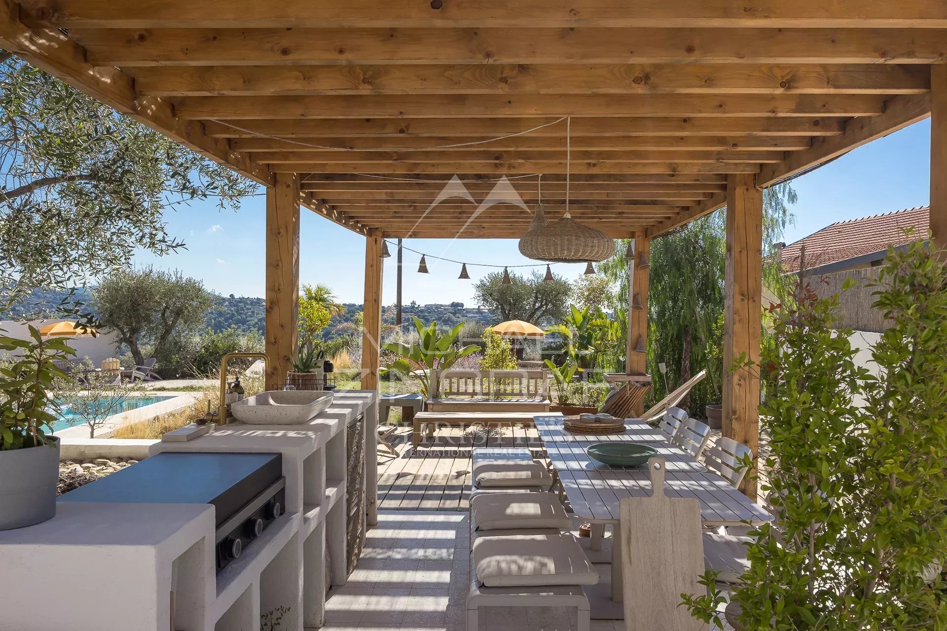 Villa terrace with swimming pool in Nice Wooden terrace with outdoor furniture and unobstructed views of nature, swimming pool in the background.