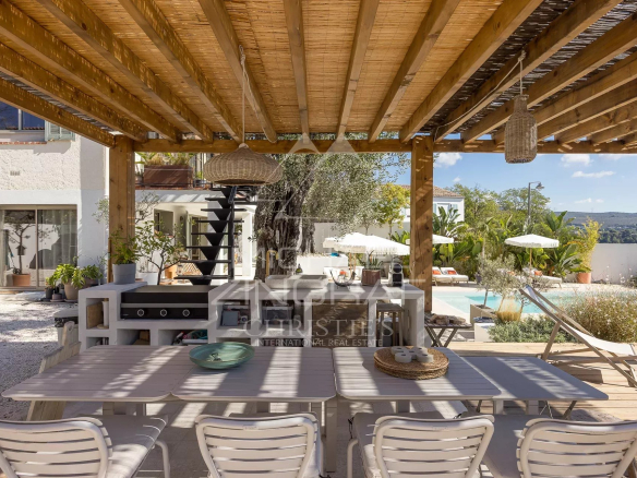 Wooden terrace with outdoor furniture and swimming pool, renovated villa in Nice.