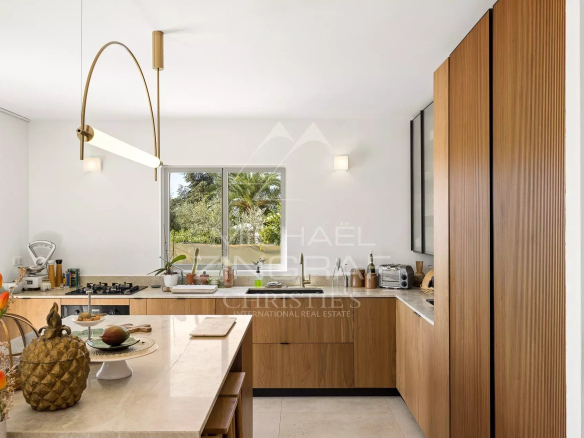 Modern and bright kitchen in a renovated villa in Nice, with wooden elements and a marble worktop.