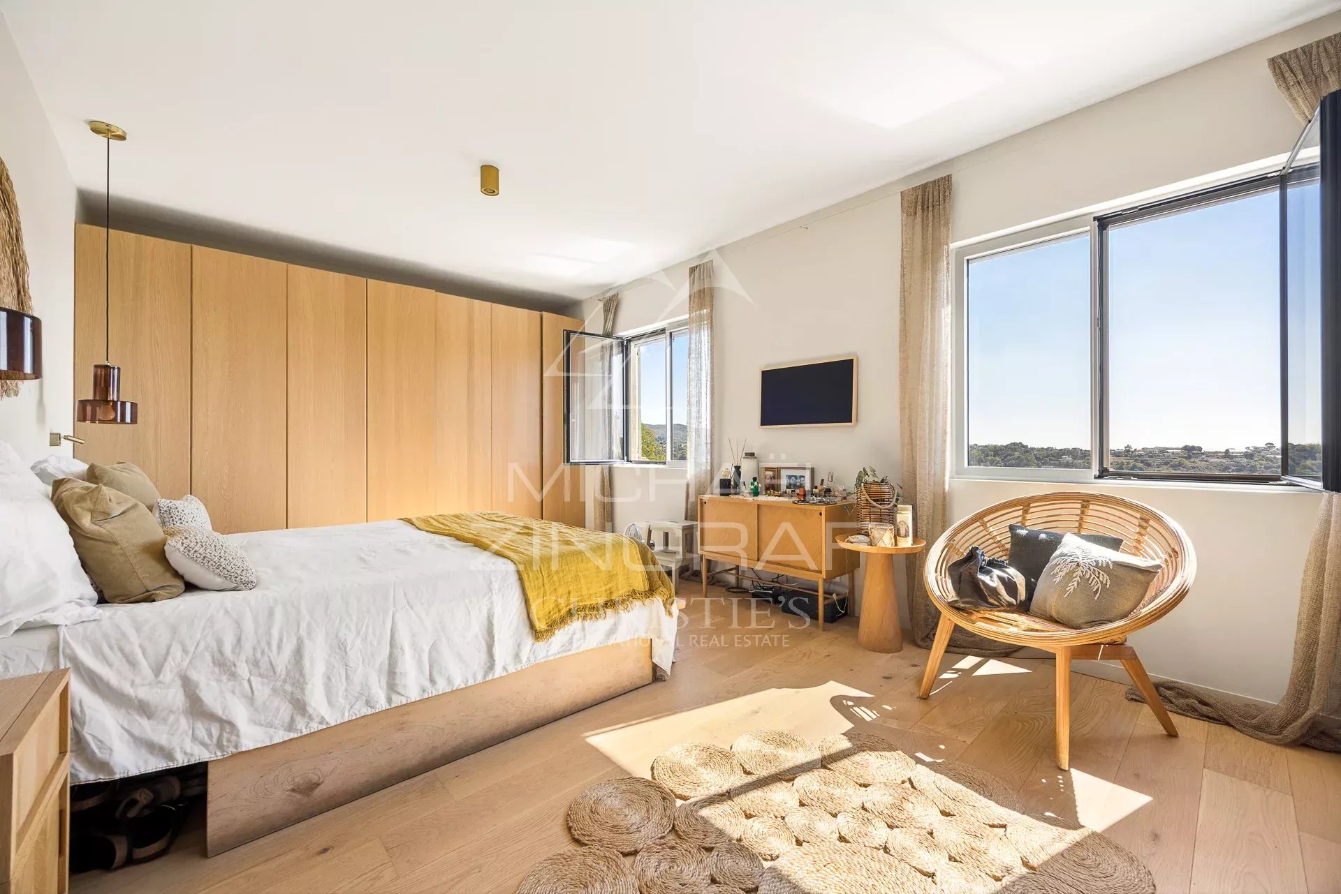 Chambre lumineuse avec vue dégagée, décoration moderne et mobilier en bois clair.