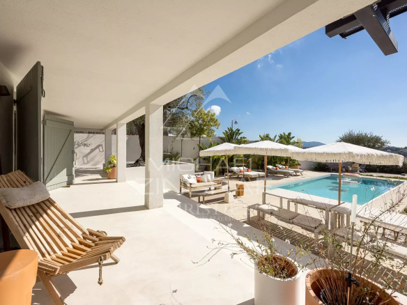 Terrasse d'une villa rénovée à Nice avec piscine et vue dégagée sur le paysage environnant.