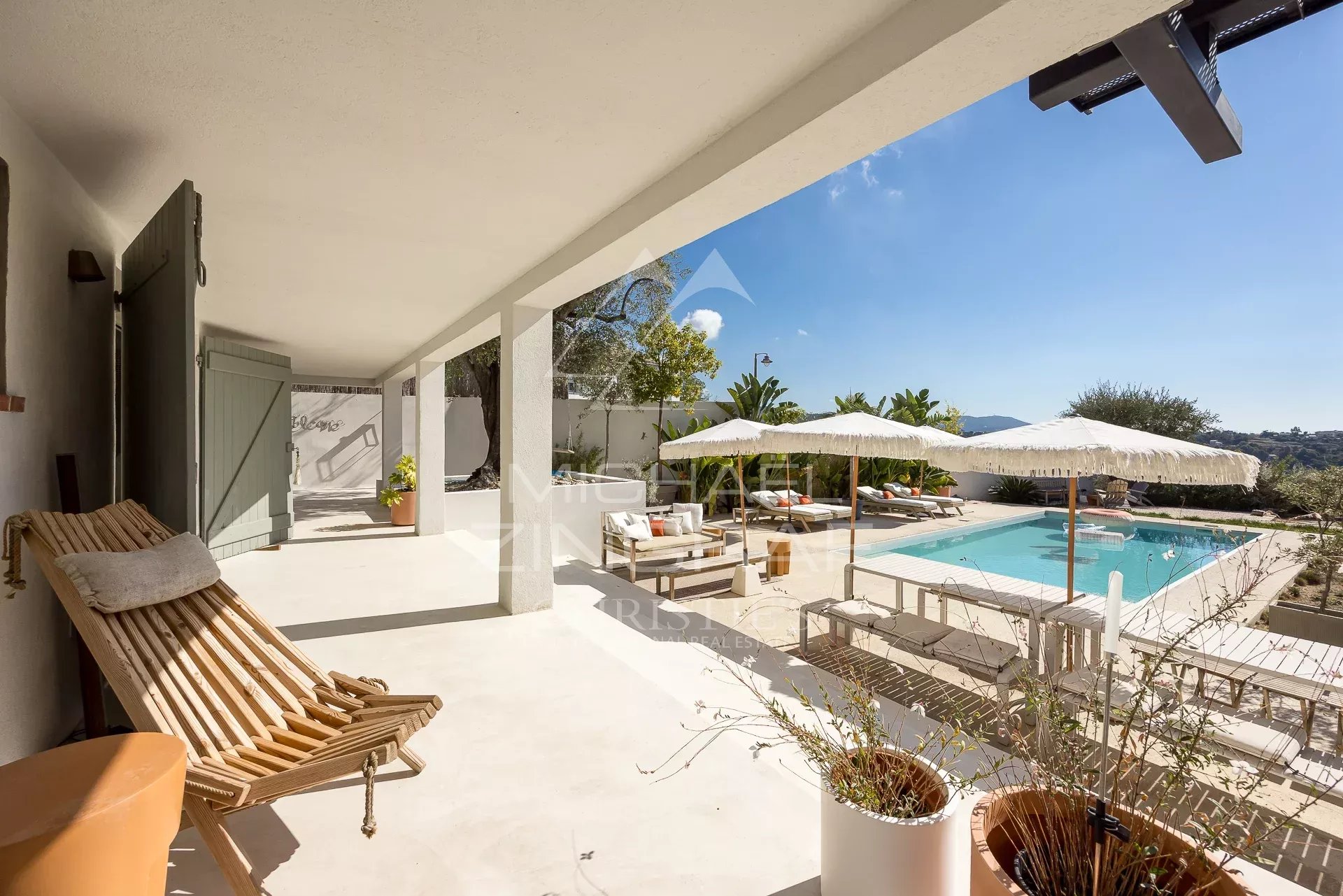 Terrasse d'une villa rénovée à Nice avec piscine et vue dégagée sur le paysage environnant.