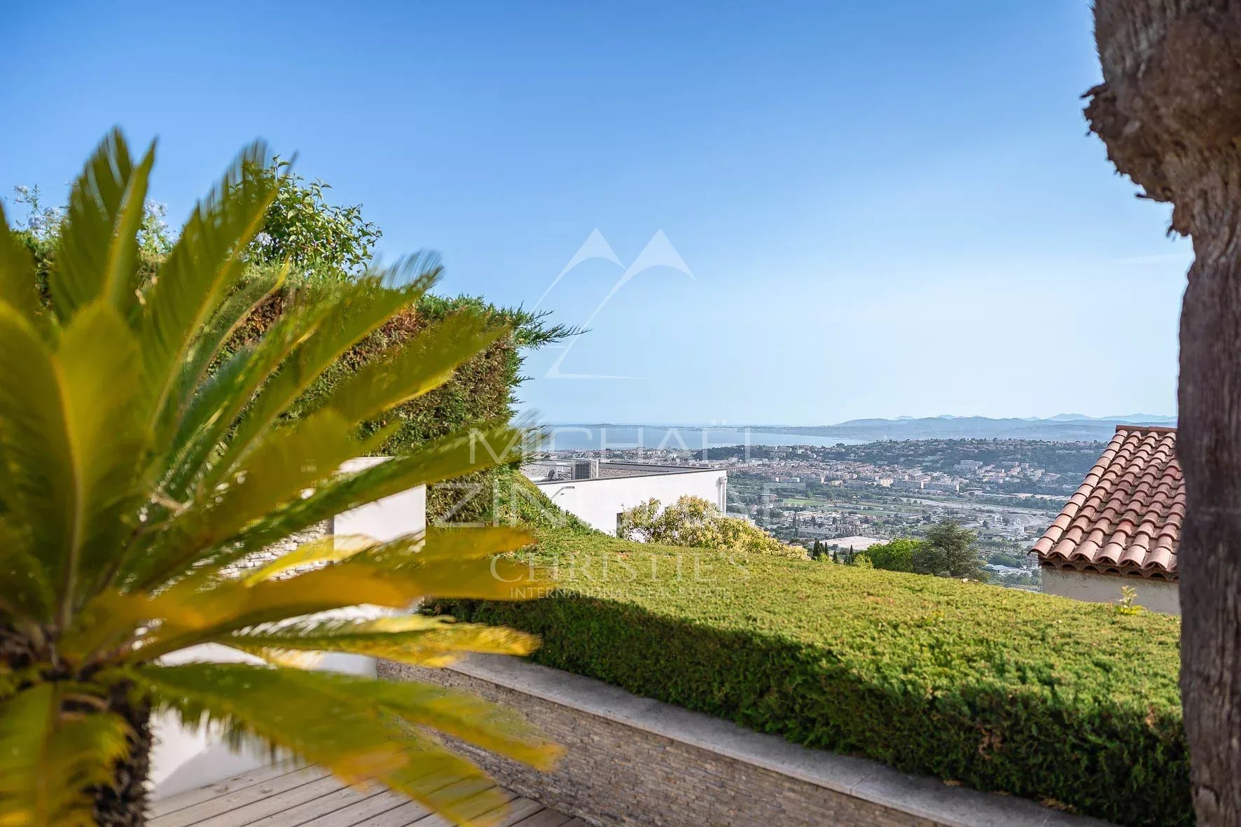 Vue dégagée sur la mer depuis une villa à Nice - Fabron, avec des plantes en avant-plan.