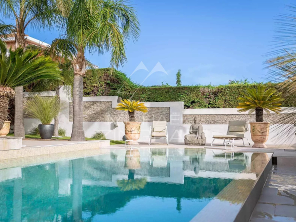 Vue d'une villa avec piscine et palmiers à Nice, Fabron, ensoleillée et proche de la mer.