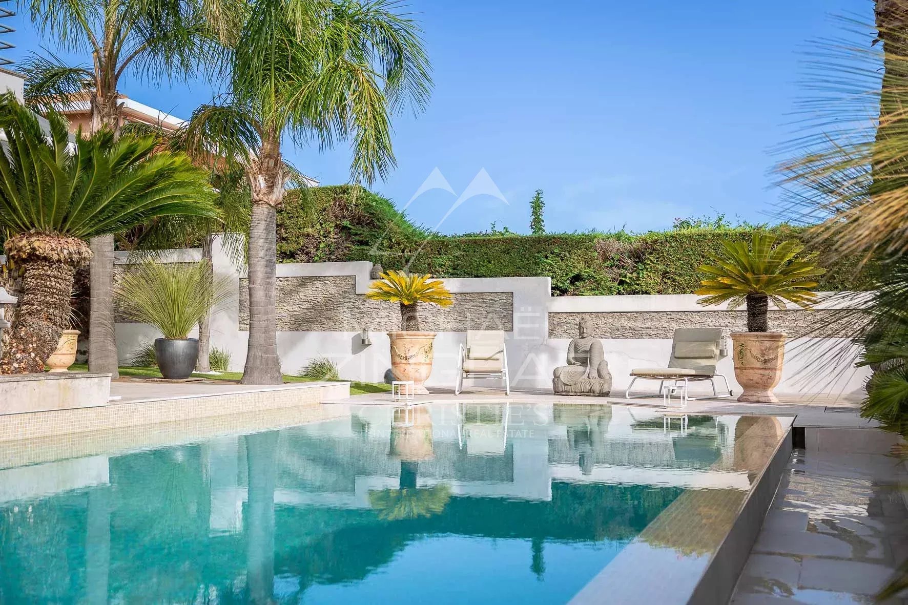 Vue d'une villa avec piscine et palmiers à Nice, Fabron, ensoleillée et proche de la mer.