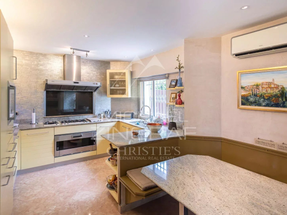 Cuisine moderne et lumineuse d'une villa à Nice, avec plan de travail en marbre et équipements intégrés.