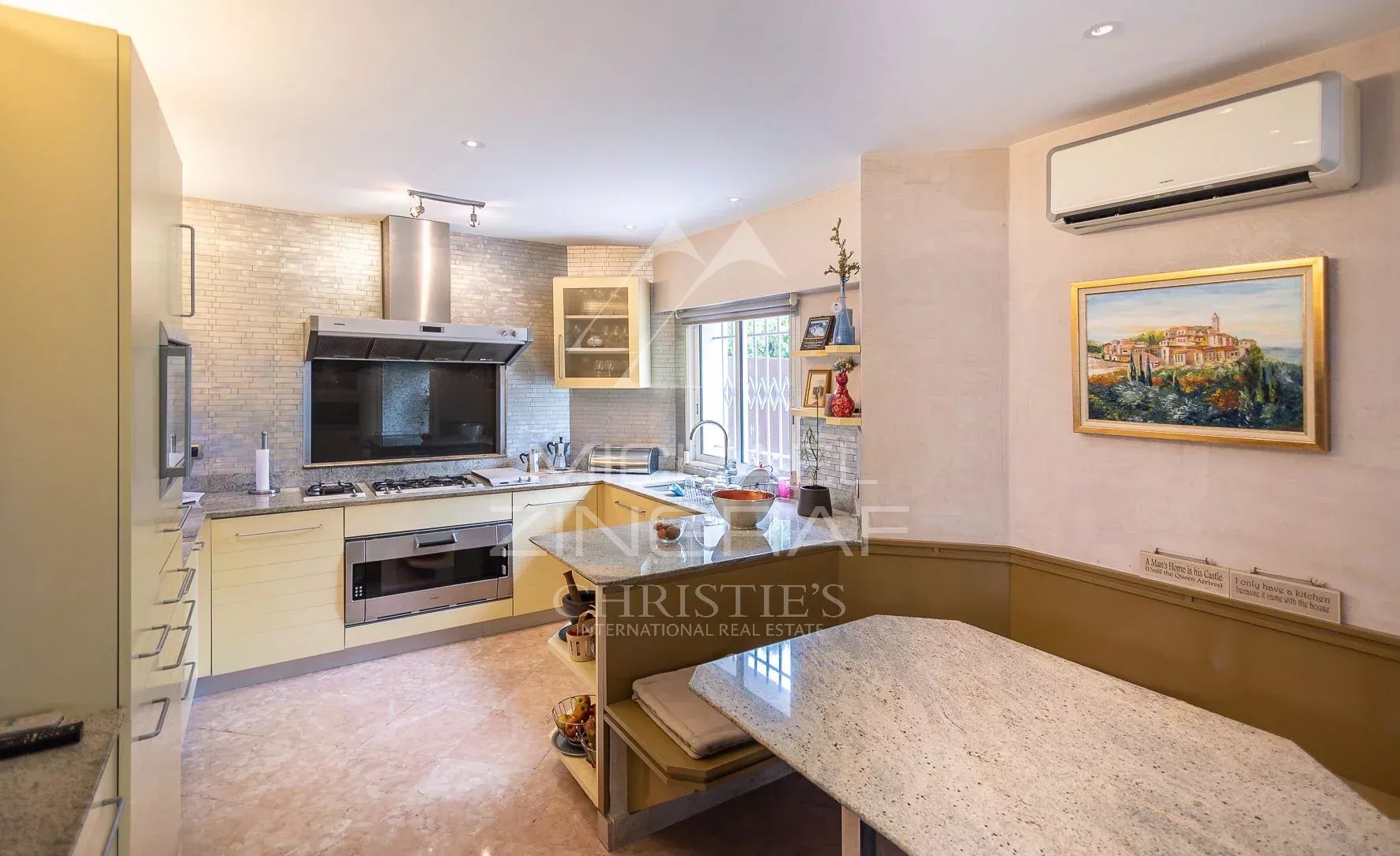 Cuisine moderne et lumineuse d'une villa à Nice, avec plan de travail en marbre et équipements intégrés.