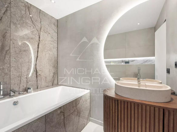 Modern bathroom with bathtub and stone sink in a renovated property in Nice.