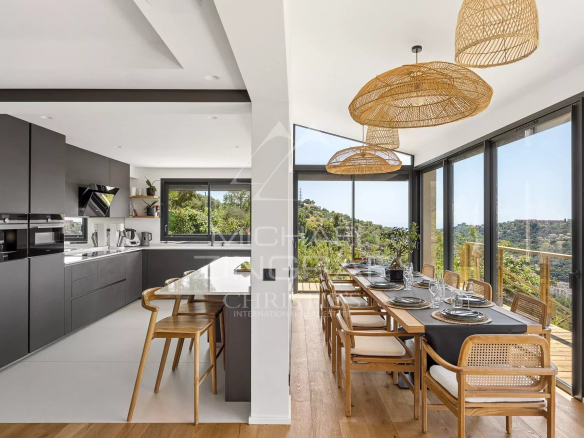 Modern kitchen and bright dining room with views of the hills in Nice.