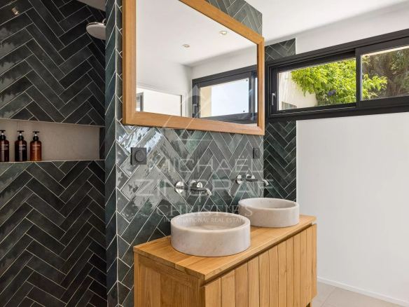 Modern bathroom with double vanity and mirror, herringbone tiled floor