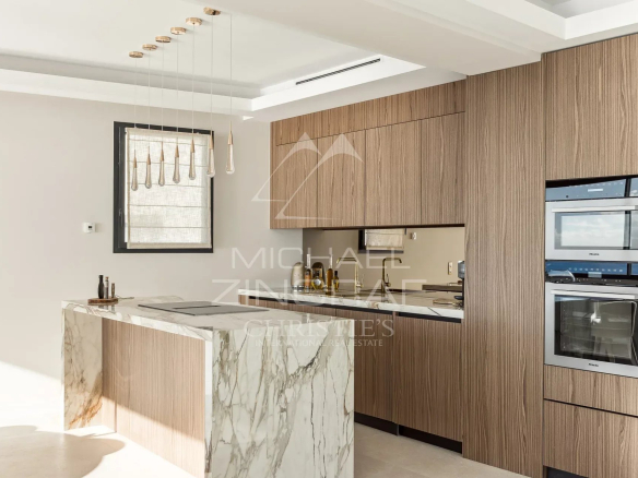Cuisine moderne avec îlot en marbre et éléments en bois dans une villa à Nice.