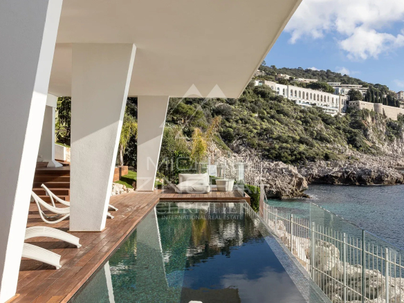 Villa moderne en bord de mer avec piscine à Nice, vue sur la colline et la mer.