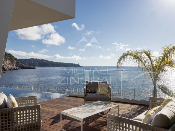 Terrasse avec vue sur la mer à Nice, mobilier moderne et palmiers.