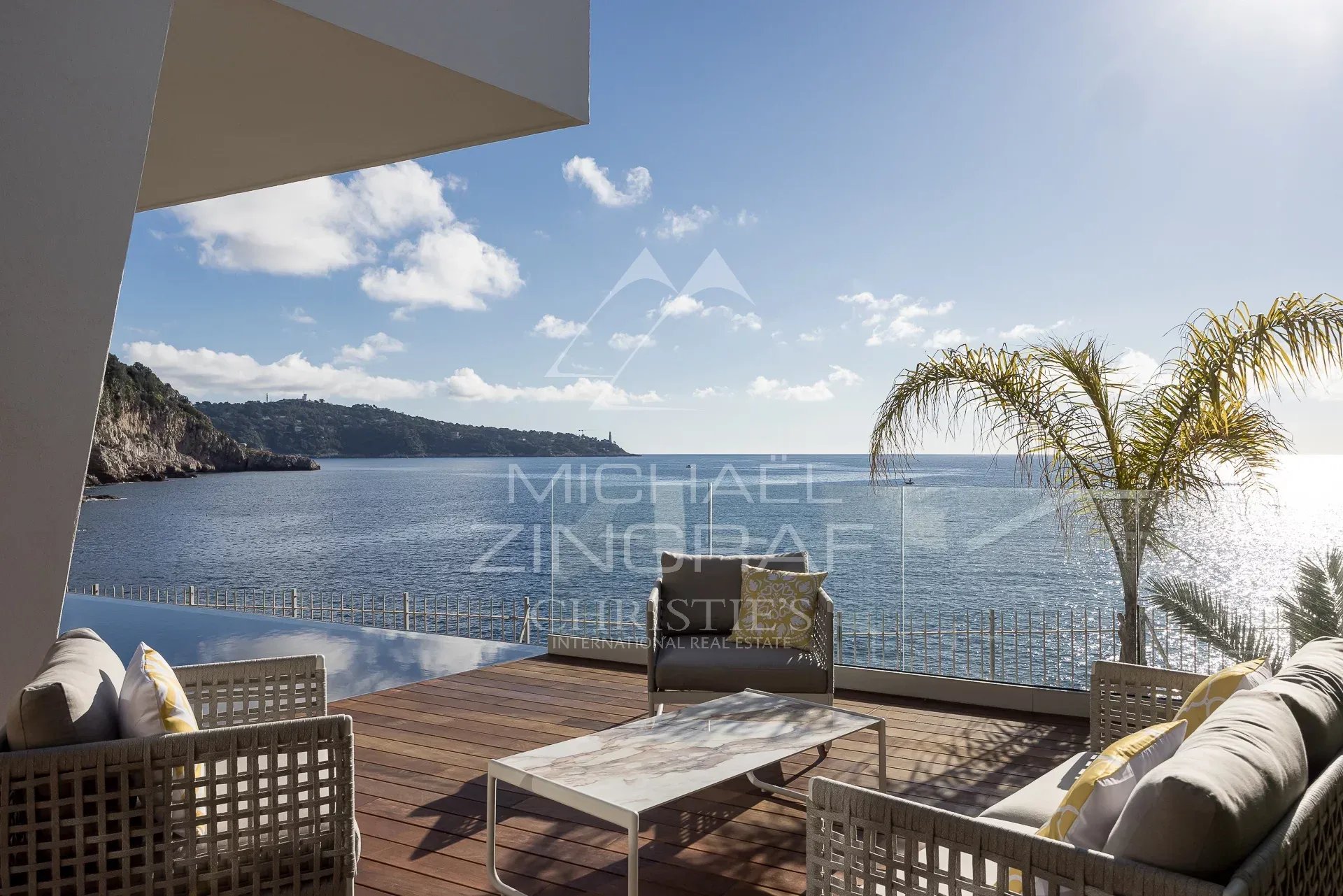 Vue sur la mer depuis une villa à Nice Terrasse avec vue sur la mer à Nice, mobilier moderne et palmiers.