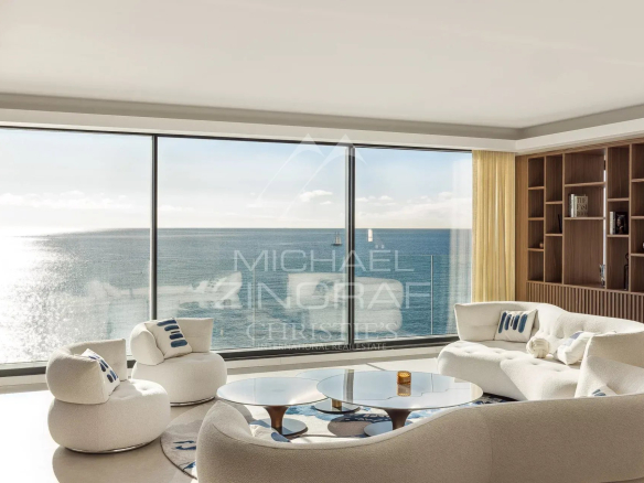 Intérieur moderne d'une villa avec vue sur la mer à Nice, mobilier contemporain et grande baie vitrée.