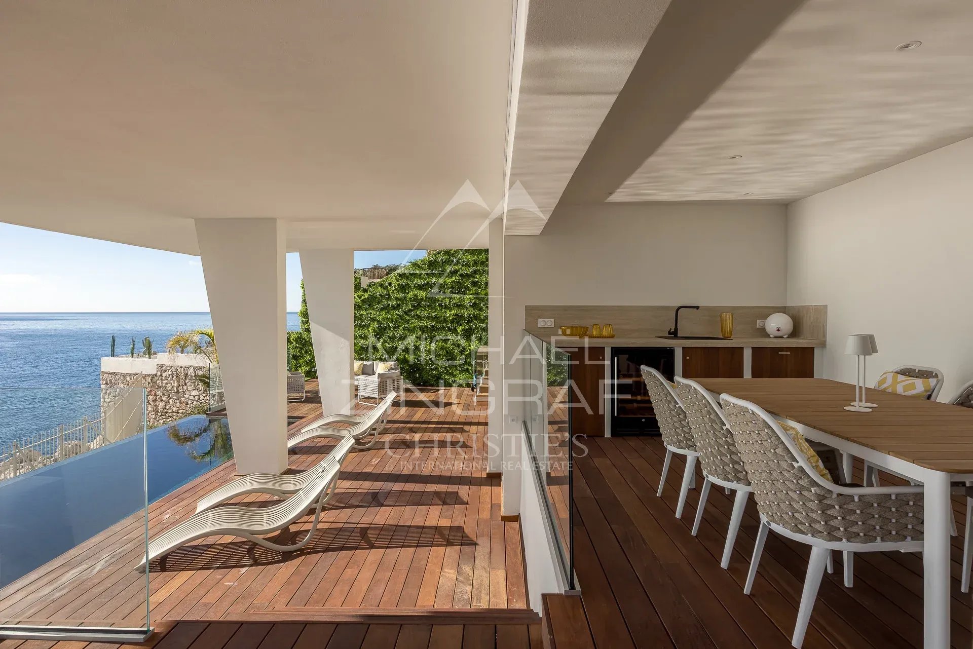 Terrasse avec vue mer à Nice Terrasse moderne avec vue sur la mer à Nice, mobilier en bois et chaises longues.