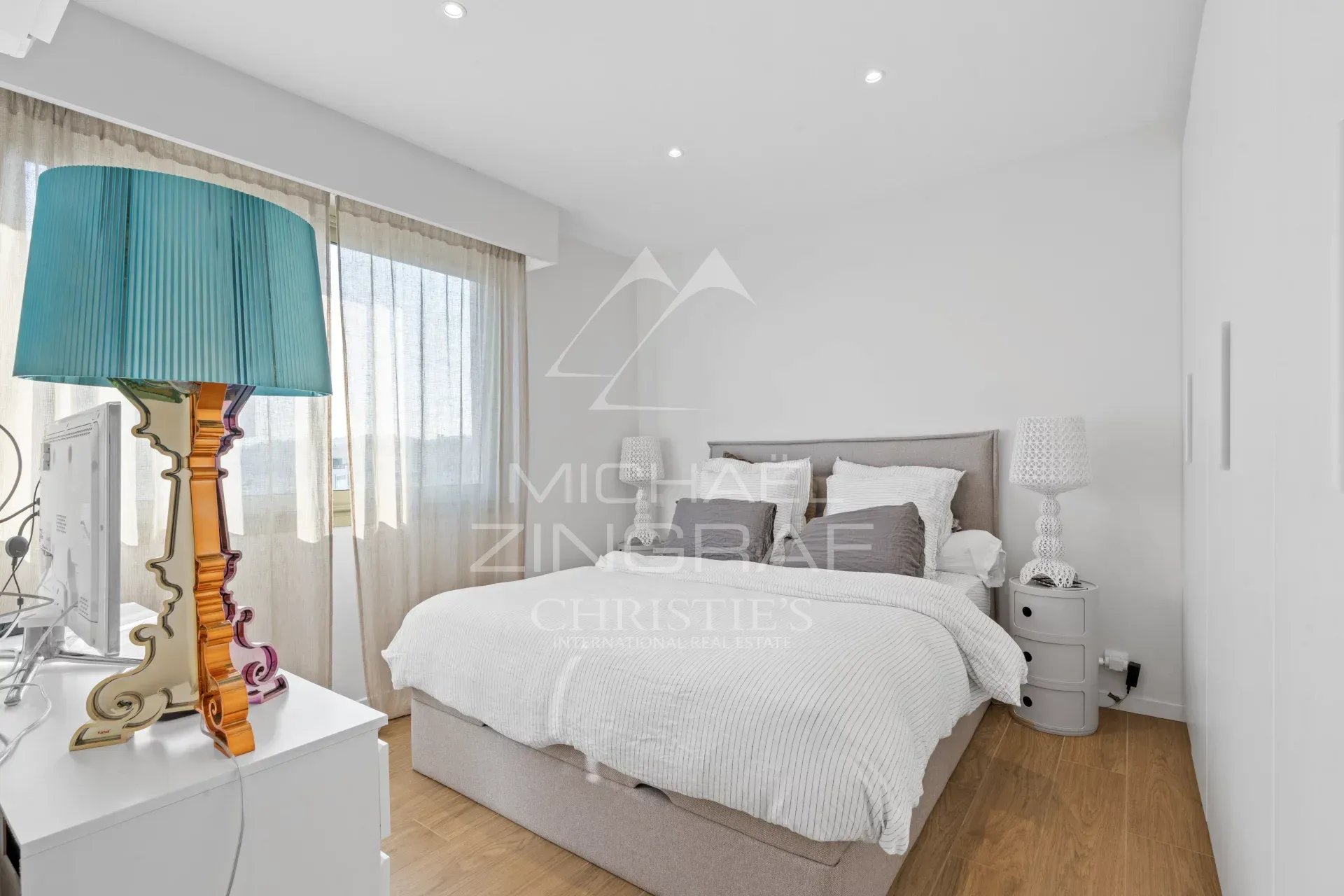 Chambre d'un appartement moderne avec lit double et fenêtres lumineuses à Cagnes-sur-Mer.