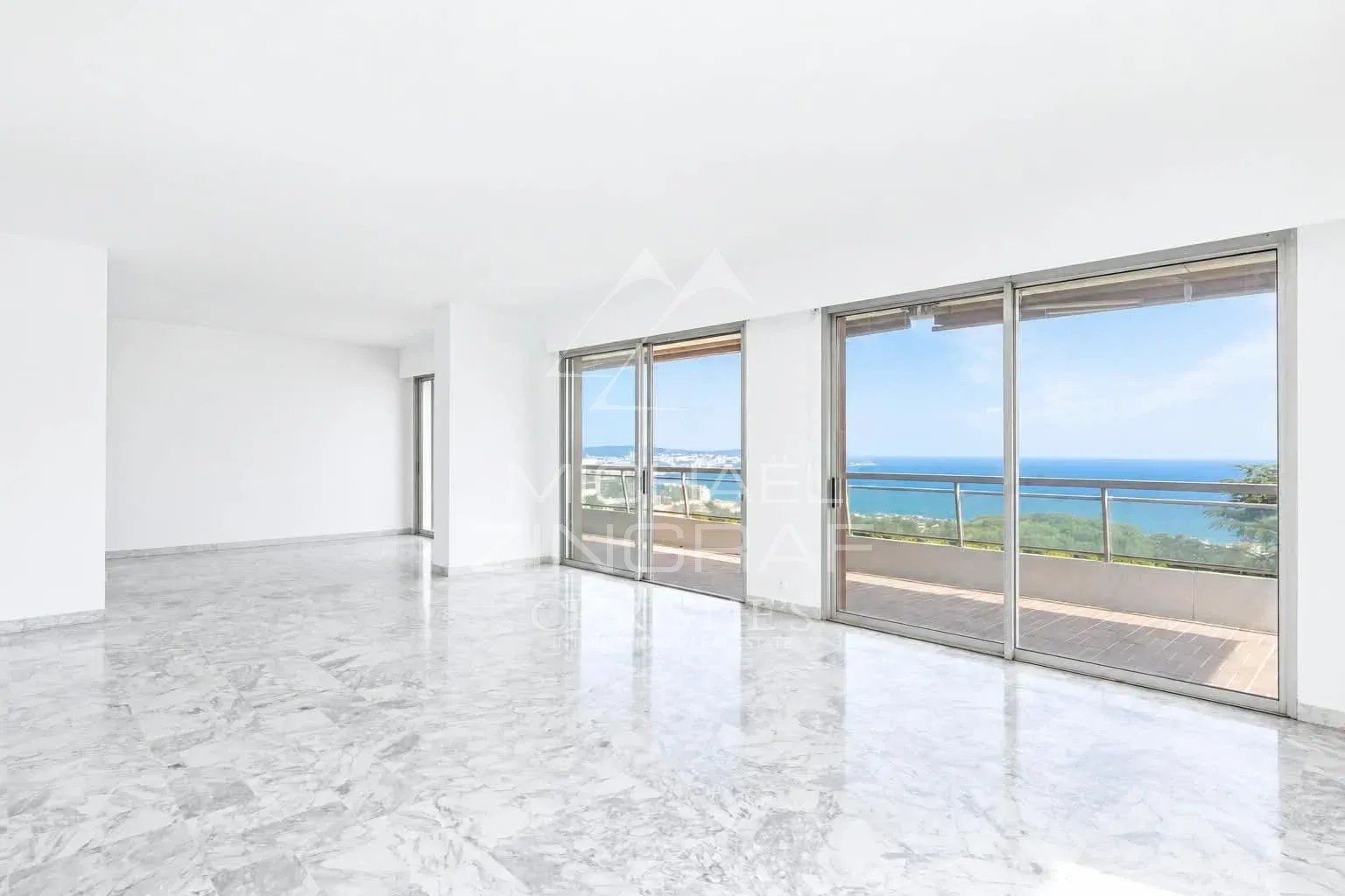 Appartement lumineux avec vue mer à Nice Fabron Intérieur d'un appartement spacieux avec vue sur la mer à Nice, fenêtres ouvertes sur une terrasse.