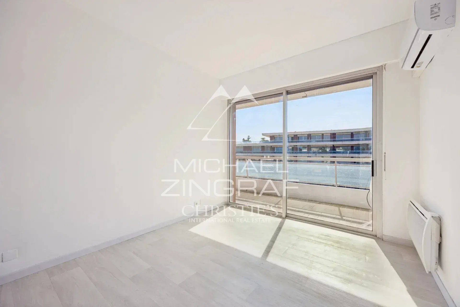 Appartement lumineux à Nice Fabron Intérieur d'un appartement lumineux avec vue sur la mer à Nice, fenêtres ouvertes sur un balcon.