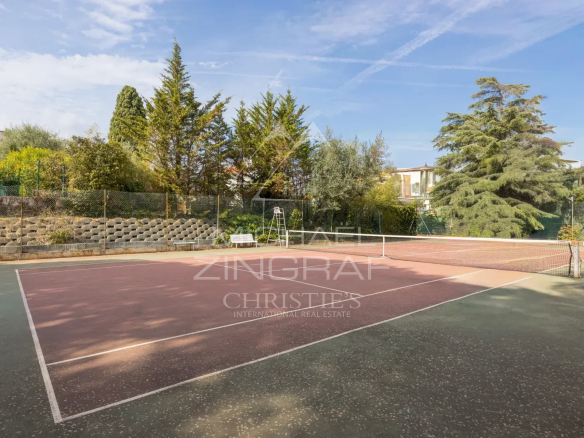 Terrains de tennis dans une résidence sécurisée à Nice Fabron, entourés d'arbres.