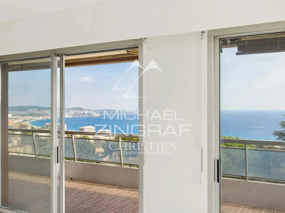 Vue panoramique sur la mer depuis un appartement à Nice Fabron, avec balustrade en verre.
