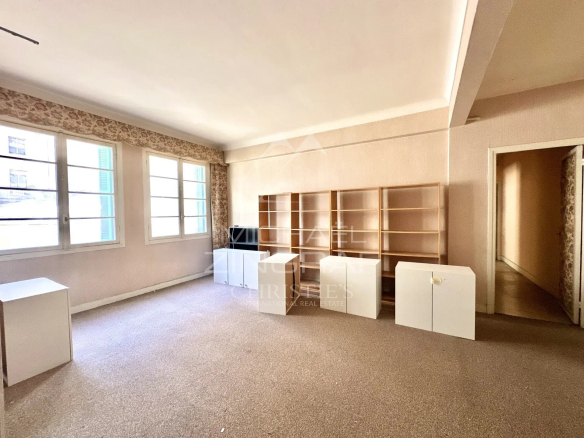 Intérieur d'un appartement à Nice, espace vide avec des étagères et des meubles blancs.
