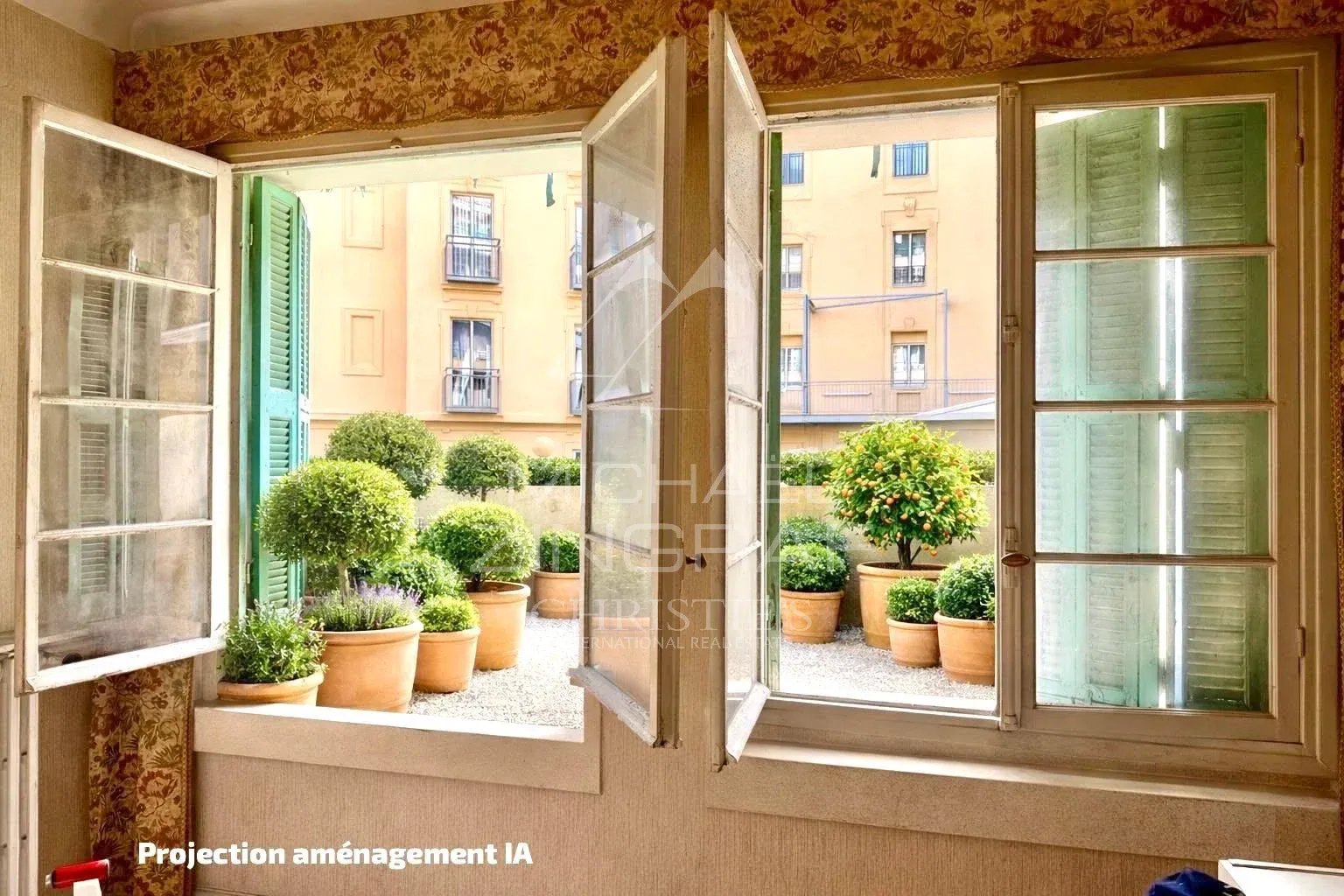 Intérieur d’un appartement à Nice Vue intérieure d'un appartement avec fenêtres ouvertes sur un jardin avec des pots de fleurs.