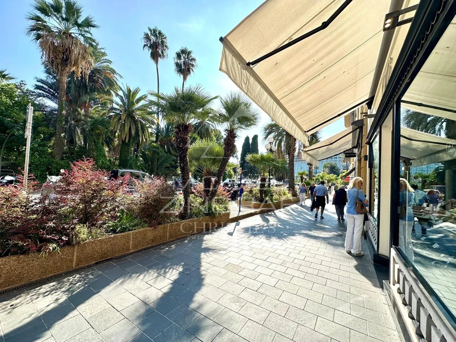 Promenade à Nice, Carré d’Or Promenade animée avec palmiers et terrasses à Nice, Carré d'Or.
