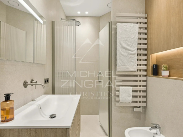 Salle de bain moderne avec baignoire, lavabo et serviettes, décorée en bois et pierre.