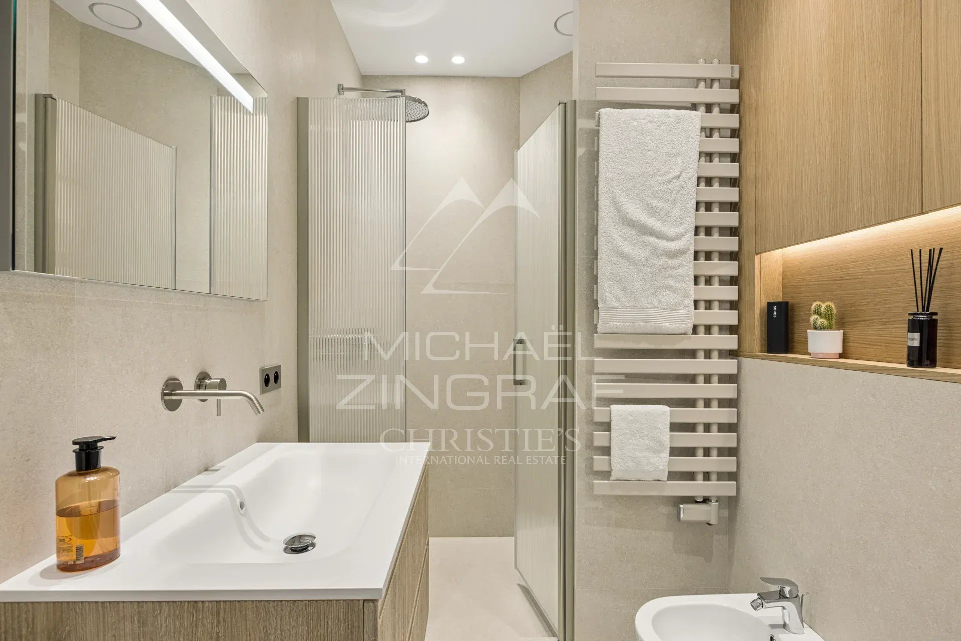 Salle de bain moderne avec baignoire, lavabo et serviettes, décorée en bois et pierre.