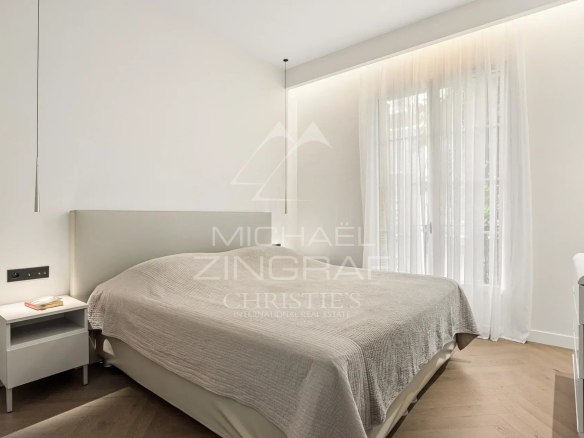 Chambre d'un appartement rénové avec lit double et lumière naturelle à Nice.