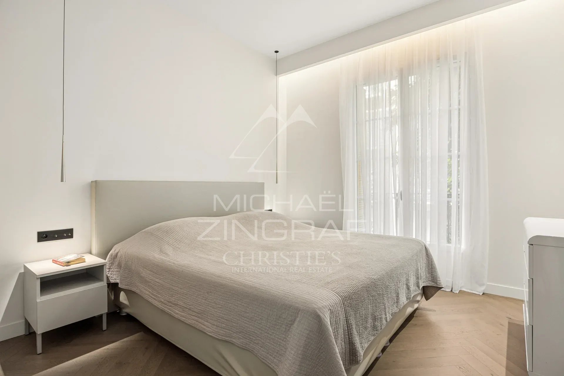 Chambre d'un appartement rénové avec lit double et lumière naturelle à Nice.