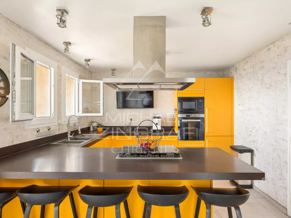 Modern kitchen with central island and yellow furniture in a villa in Aspremont.
