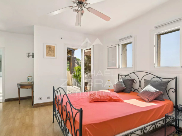 Room in a Provençal villa in Aspremont with bed and windows offering panoramic views.
