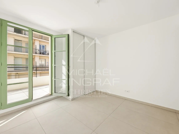 Intérieur d'un appartement neuf à Nice avec fenêtres ouvertes sur un balcon.