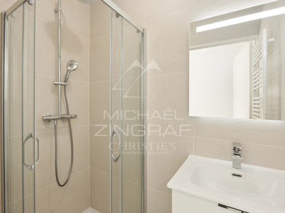 Salle de bain moderne avec douche vitrée et lavabo dans un appartement neuf à Nice.