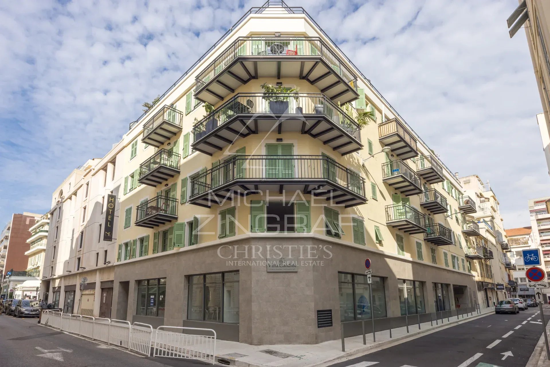 Immeuble moderne à Nice avec balcons et terrasse, situé dans un quartier animé.