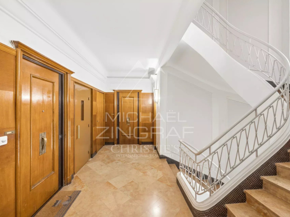 Entrance to a building with wooden doors and a marble staircase
