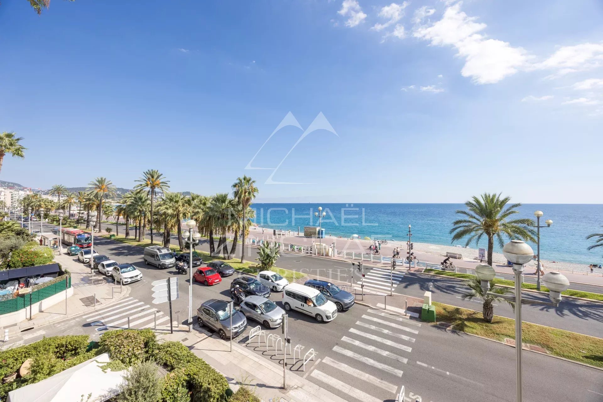 View of the Promenade des Anglais in Nice View of the Promenade des Anglais and the sea in Nice, with palm trees and cars on the road.